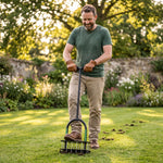 Man aerating a lawn with the manual lawn aerator