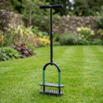 Full-length manual lawn aerator on a lawn